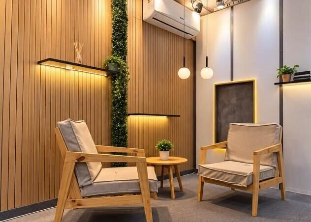 Set podcast con dos sillones de madera, revestimiento de listones y luz cálida
